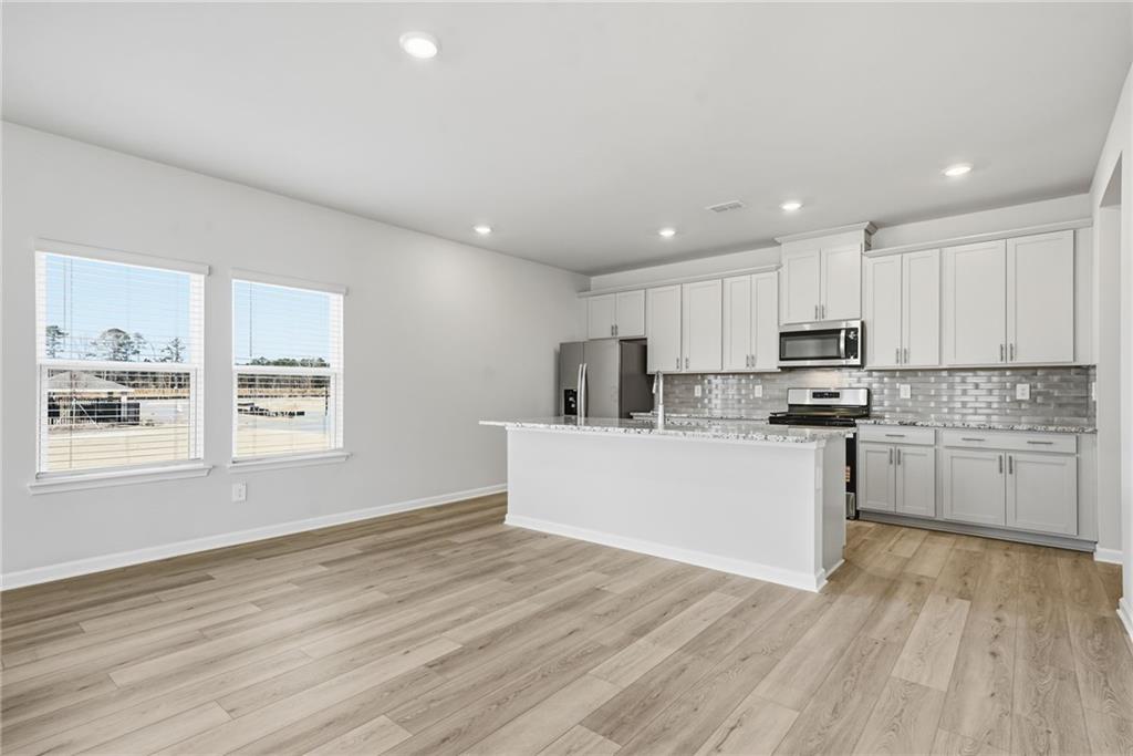 1503 Wild Fox Run Lawrenceville, GA 30045 - Photo 9 of 46 a kitchen with granite countertop white cabinets and white appliances
