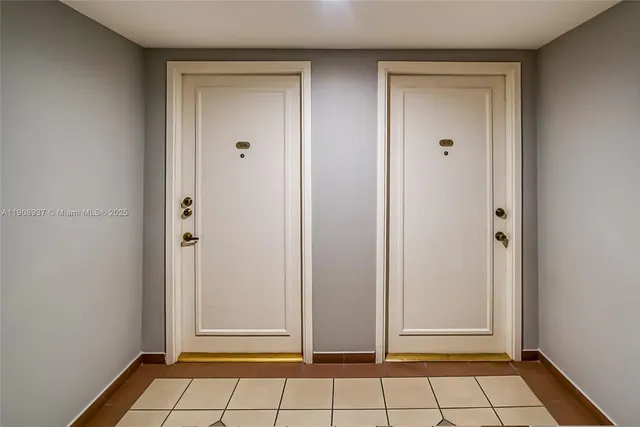 a front view of a building with lot of cars and trees