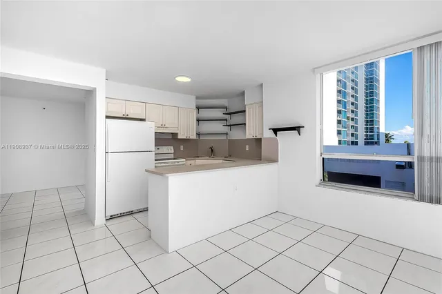 a view of a kitchen with refrigerator and cabinets