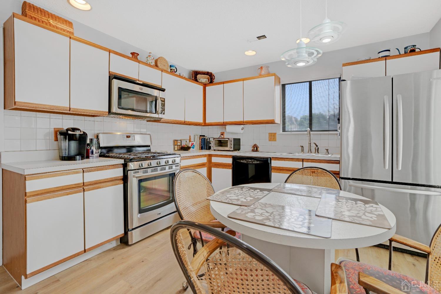 58 Gate House Lane Edison, NJ 08820 - Photo 11 of 37 a kitchen with stainless steel appliances granite countertop a sink a stove a refrigerator cabinets and dining table