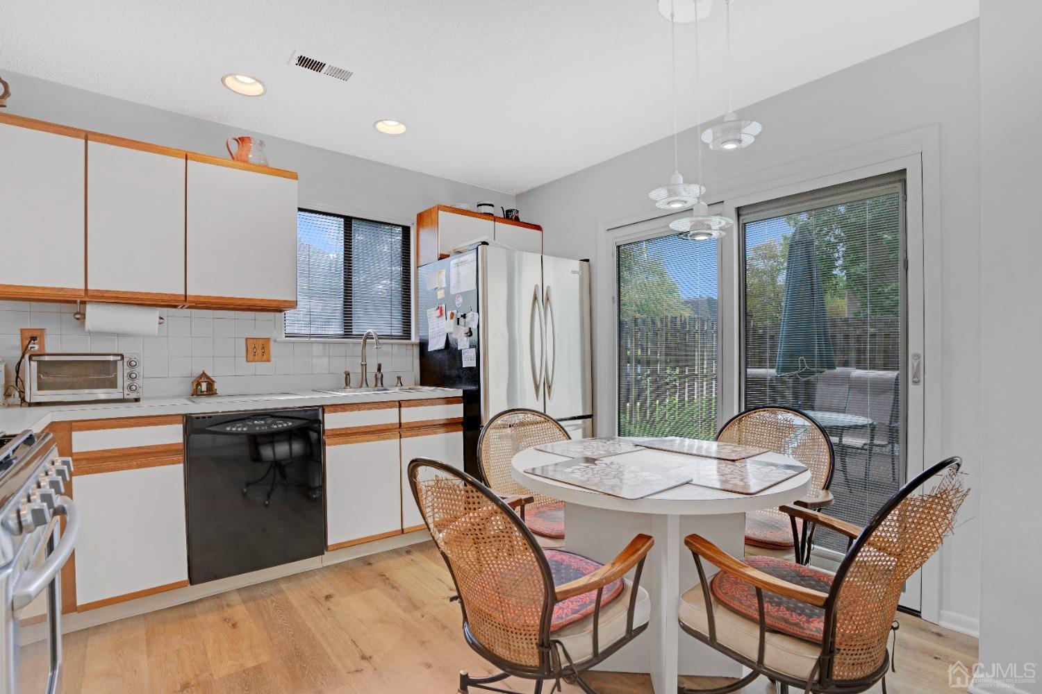 58 Gate House Lane Edison, NJ 08820 - Photo 12 of 37 a kitchen with stainless steel appliances granite countertop a stove top oven a sink dishwasher and white cabinets with wooden floor