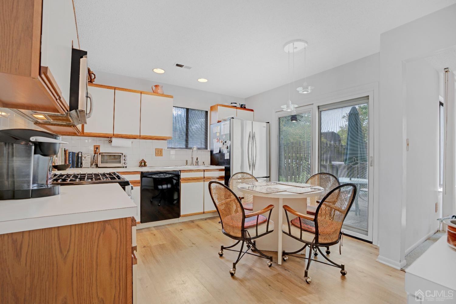 58 Gate House Lane Edison, NJ 08820 - Photo 13 of 37 a kitchen with a table chairs refrigerator and cabinets
