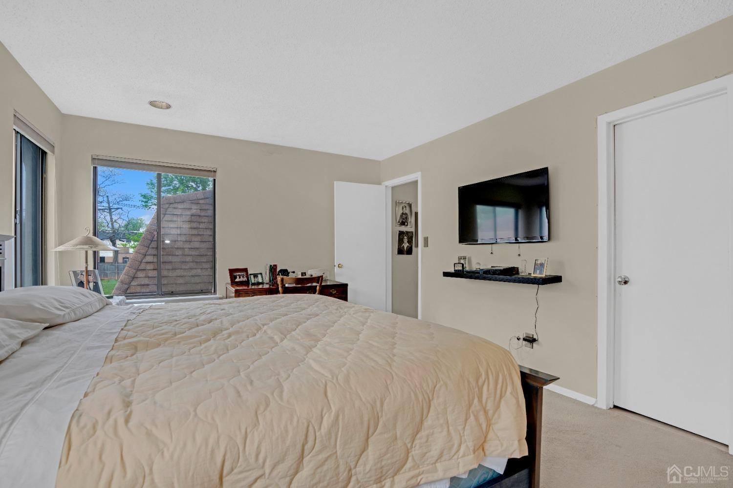 58 Gate House Lane Edison, NJ 08820 - Photo 24 of 37 a bedroom with a bed and a flat screen tv