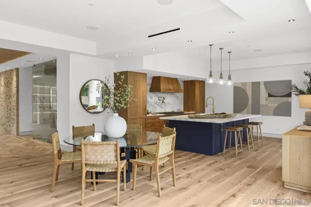 a dining room with wooden floor a glass table and chairs