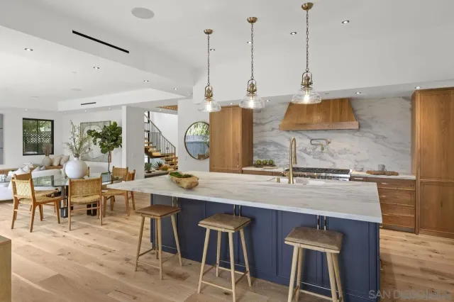 a kitchen with stainless steel appliances granite countertop a sink a stove and a wooden floors