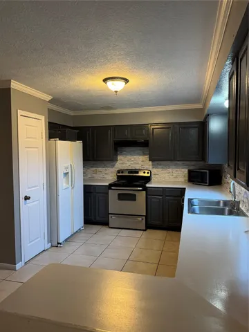 a kitchen with stainless steel appliances kitchen island granite countertop a refrigerator and a stove