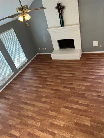 a view of a livingroom with wooden floor and a ceiling fan
