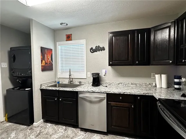 a kitchen with stainless steel appliances granite countertop a sink stove and cabinets