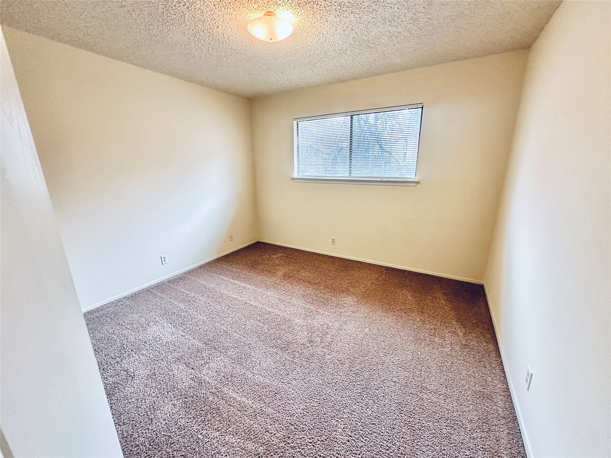 12504 Tree Line Drive, Unit B Austin, TX 78729 - Photo 19 of 22 Carpeted spare room with a textured ceiling and baseboards