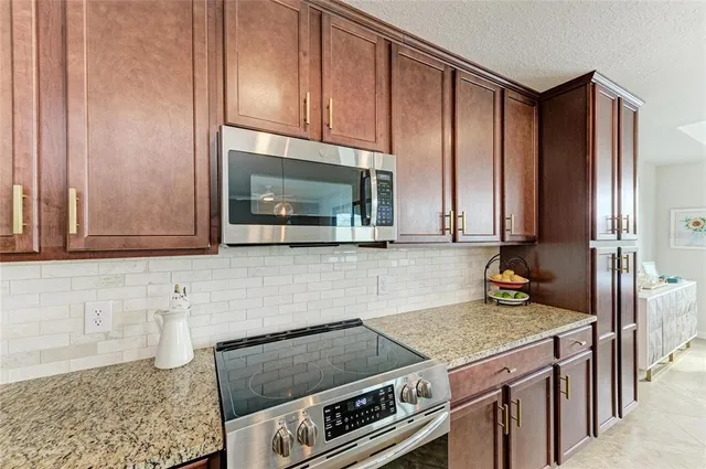 a kitchen with a refrigerator a stove top oven a sink dishwasher and white cabinets next to a window