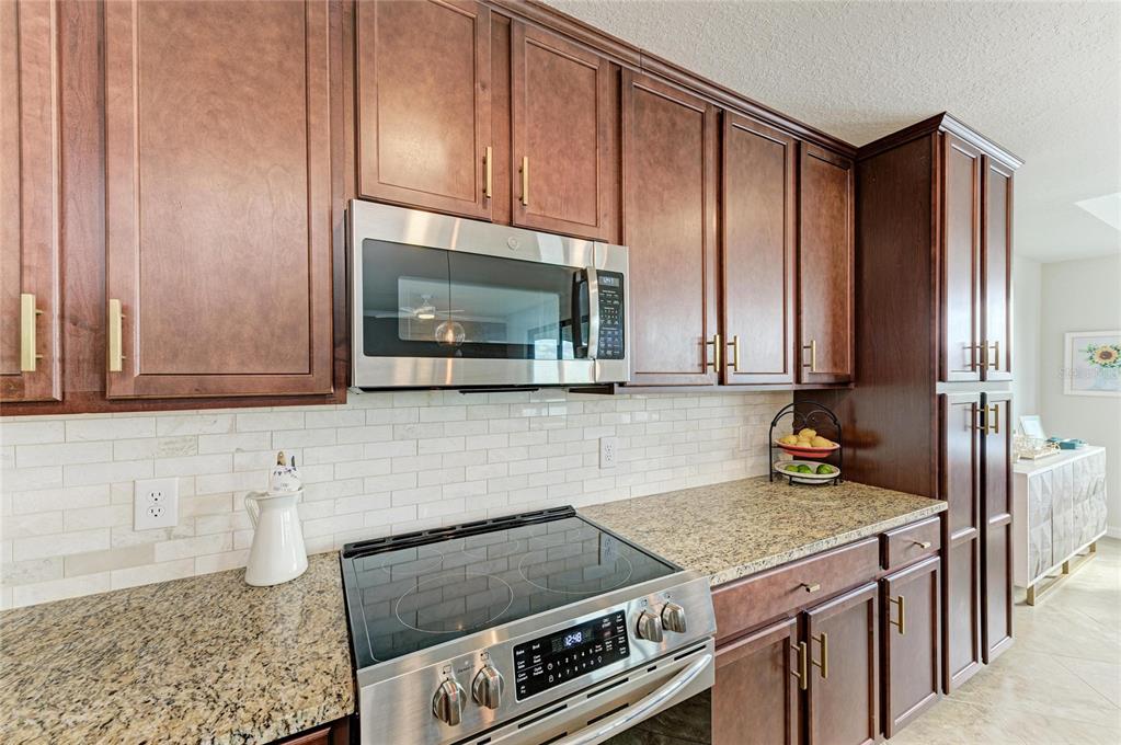 17006 Vardon Terrace, Unit 206 Lakewood Ranch, FL 34211 - Photo 16 of 79 a kitchen with granite countertop a stove a sink and a microwave