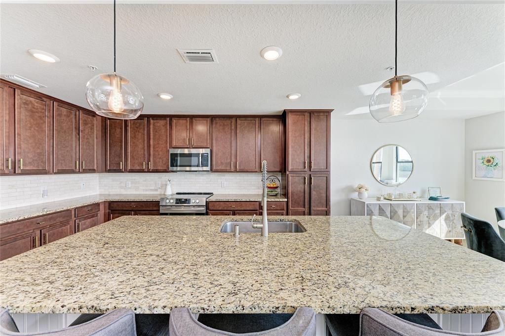 17006 Vardon Terrace, Unit 206 Lakewood Ranch, FL 34211 - Photo 17 of 79 a kitchen with stainless steel appliances granite countertop a sink a stove and a wooden cabinets