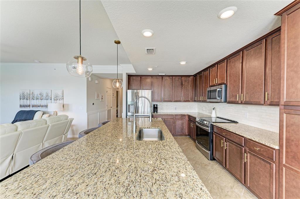 17006 Vardon Terrace, Unit 206 Lakewood Ranch, FL 34211 - Photo 18 of 79 a large kitchen with kitchen island a large counter top space a sink stainless steel appliances and cabinets