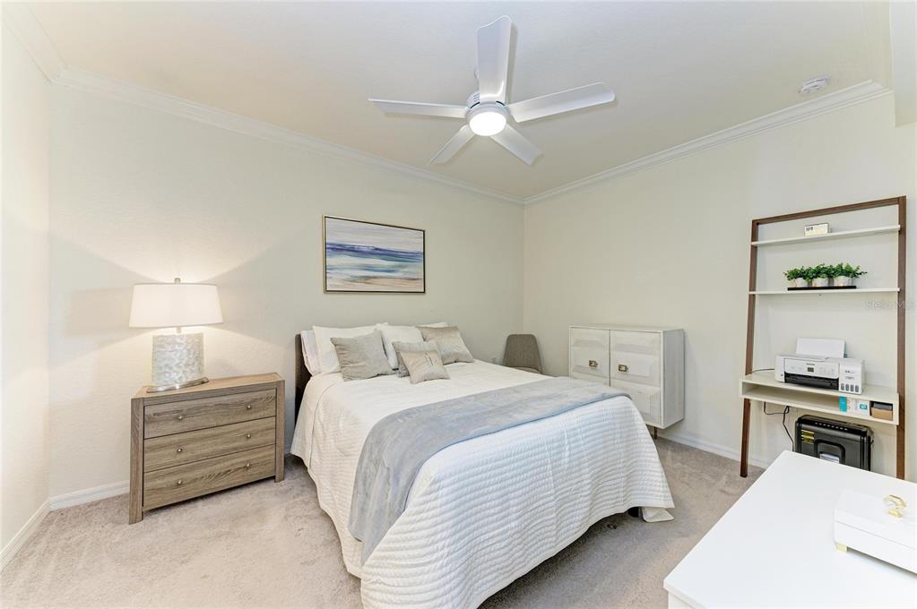 17006 Vardon Terrace, Unit 206 Lakewood Ranch, FL 34211 - Photo 25 of 79 a bedroom with a bed a chandelier and a dresser