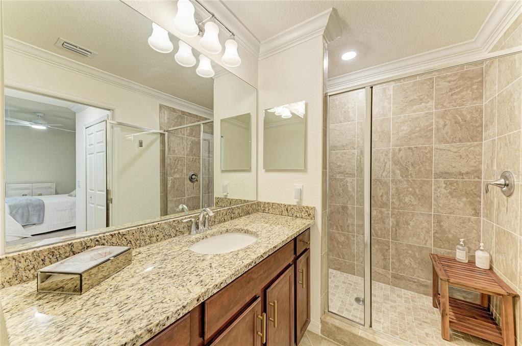 17006 Vardon Terrace, Unit 206 Lakewood Ranch, FL 34211 - Photo 28 of 79 a bathroom with a granite countertop sink a mirror and a shower