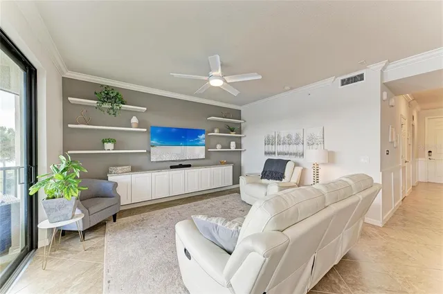 a living room with furniture and a large window with kitchen view