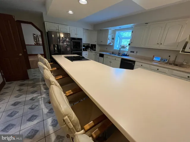 a kitchen with stainless steel appliances a sink a stove top oven a counter space and cabinets