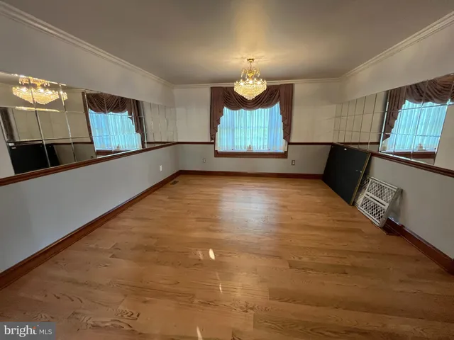 an empty room with wooden floor and window