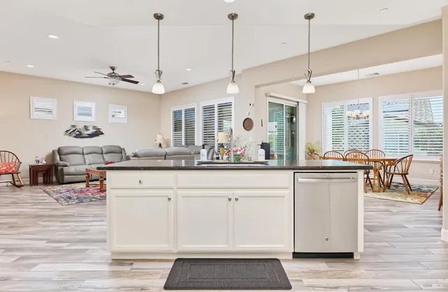 a large kitchen with kitchen island a large counter space a sink appliances and living room view