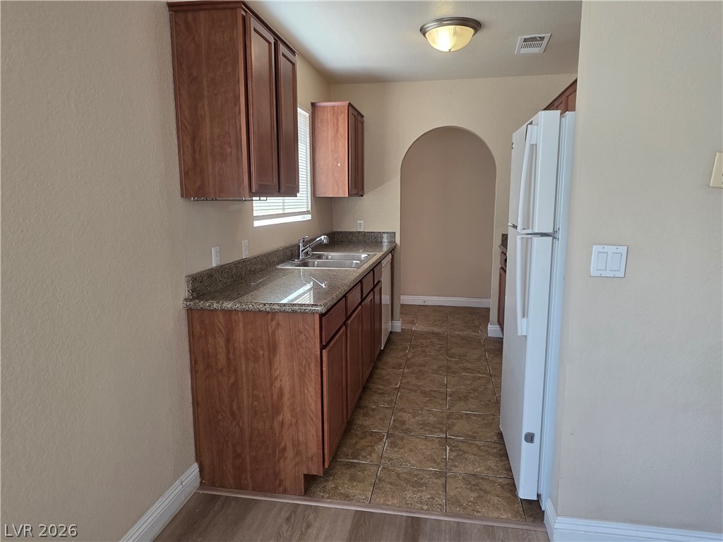 1844 North Decatur Boulevard, Unit 204 Las Vegas, NV 89108 - Photo 5 of 21 Rich wood cabinetry and stone counters define this classic kitchen layout.