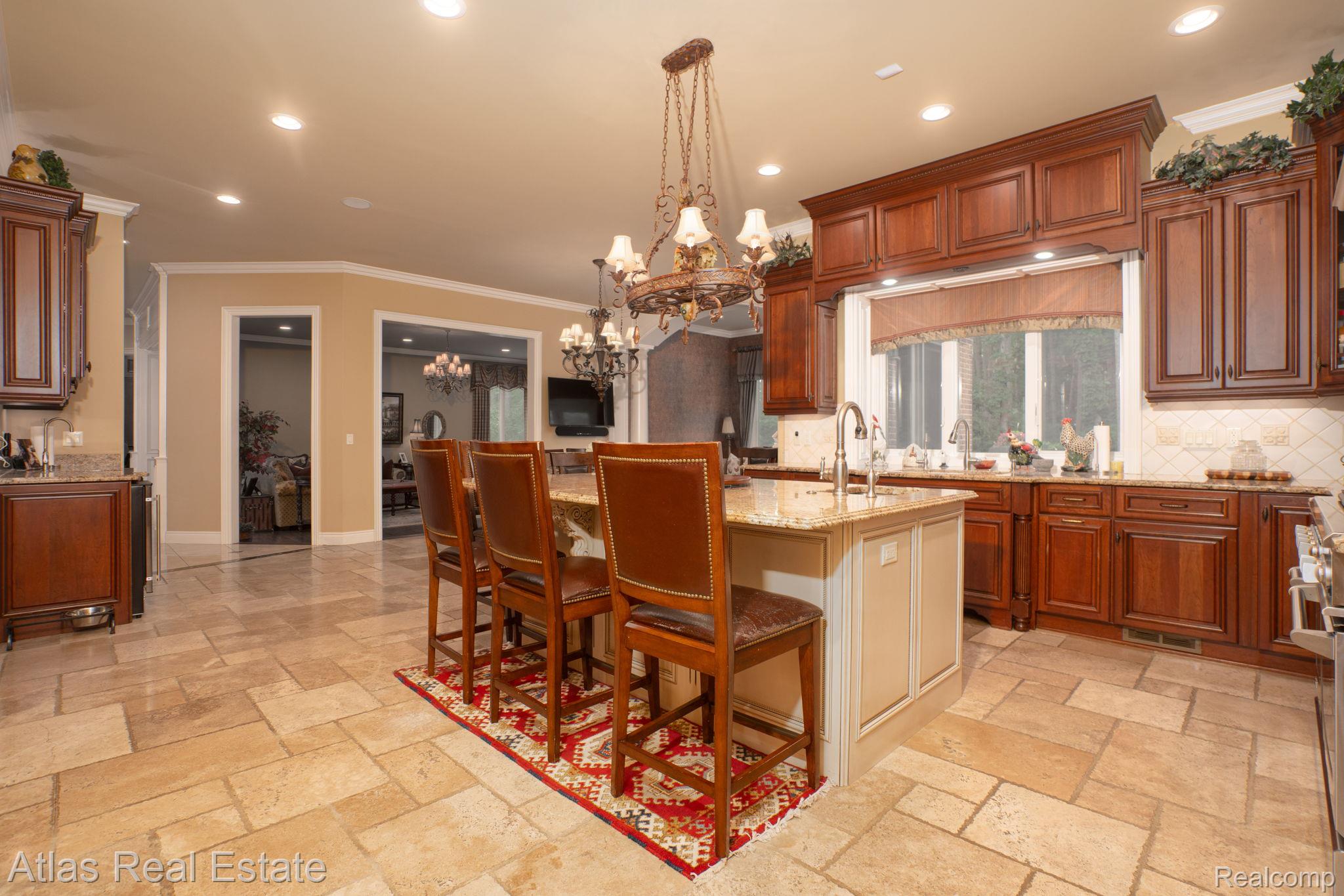 10380 South State Road Goodrich, MI 48438 - Photo 42 of 87 Gourmet kitchen featuring a central island with integrated sink, stone countertops, rich wood cabinetry, tile backsplash, and recessed lighting