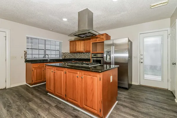 a kitchen with stainless steel appliances granite countertop a stove a refrigerator and a sink