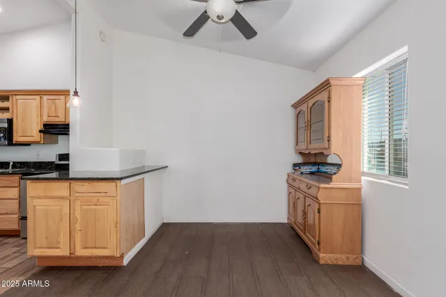 a kitchen with stainless steel appliances granite countertop a stove a sink and a refrigerator with wooden floors