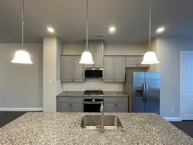 a kitchen with a sink cabinets and stainless steel appliances
