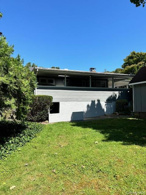 4 Oakhurst Road Hampton Bays, NY 11946 - Photo 13 of 13 Rear view of house with a lawn, a chimney, and a sunroom