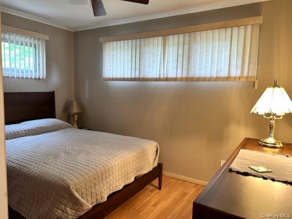 4 Oakhurst Road Hampton Bays, NY 11946 - Photo 6 of 13 Bedroom featuring light wood finished floors, ornamental molding, and a ceiling fan