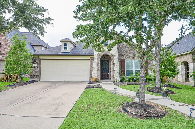 a front view of a house with a yard and a fountain