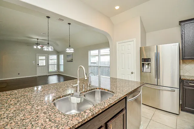 a kitchen with stainless steel appliances granite countertop a sink refrigerator and microwave