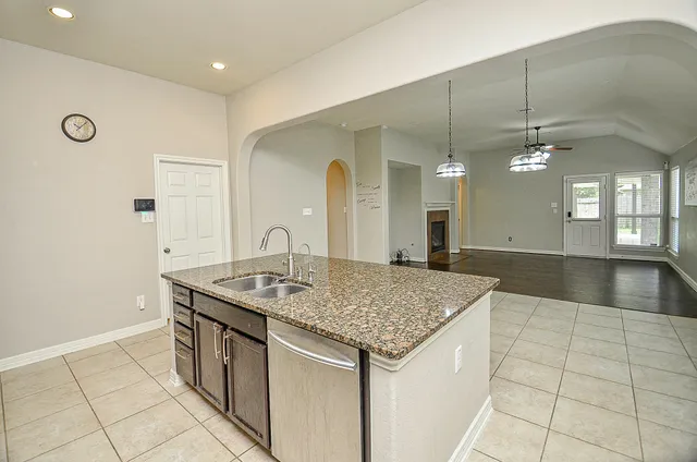 a kitchen with a sink a counter space and chandelier