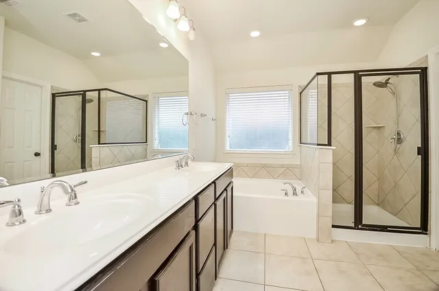 a spacious bathroom with a bathtub shower sink and mirror