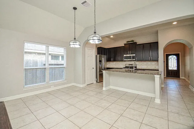 a kitchen with stainless steel appliances granite countertop a stove a sink and a refrigerator