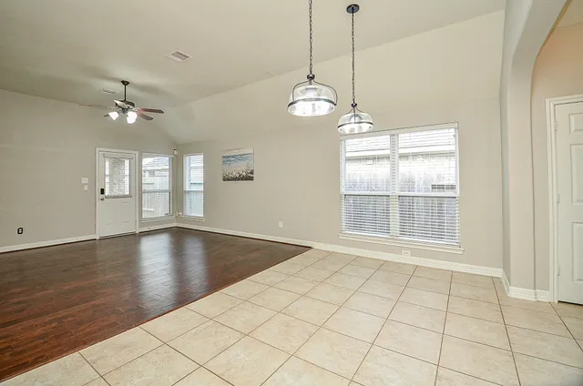 a view of an room with wooden floor and chandelier fan