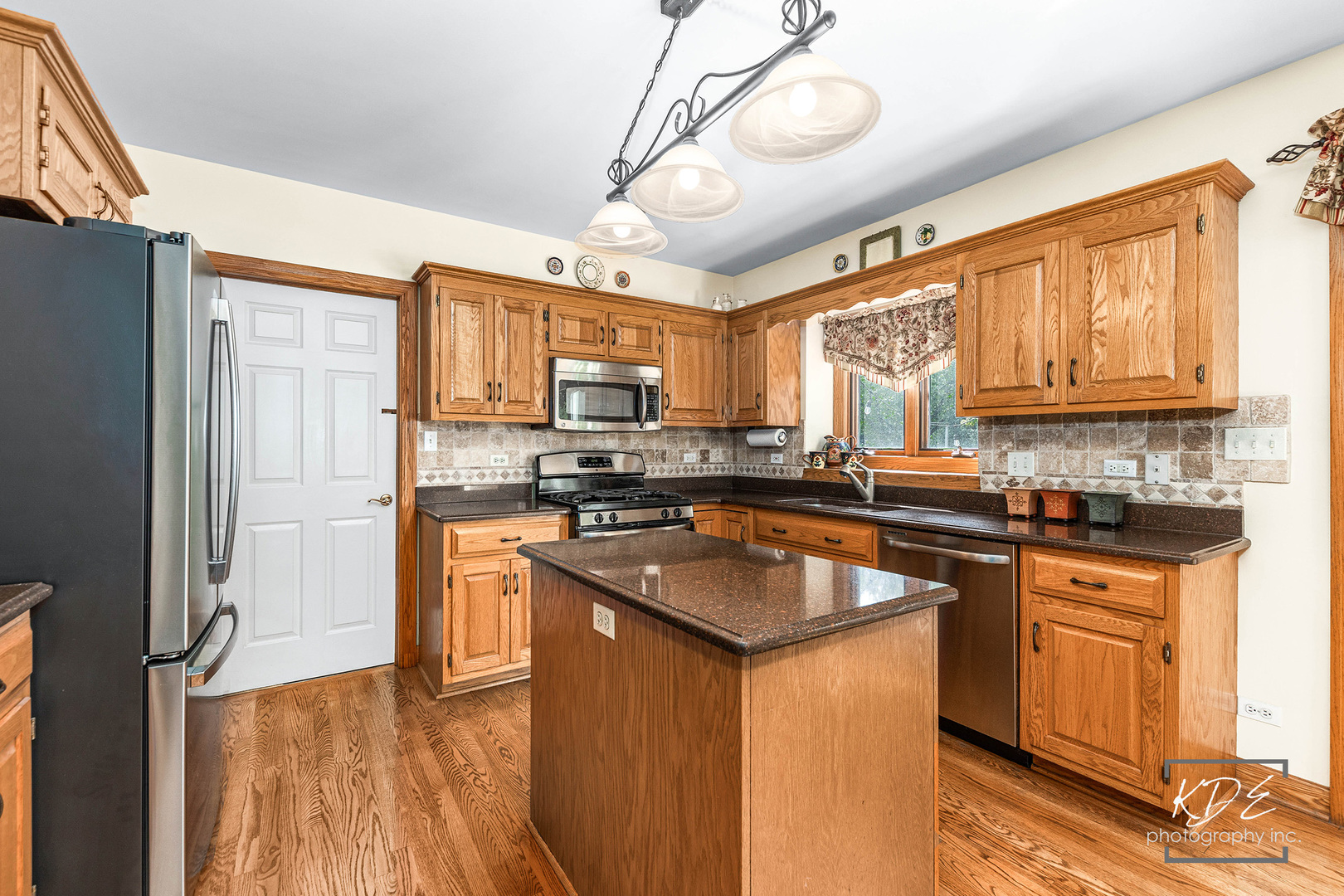 1032 Hamlet Road Naperville, IL 60564 - Photo 11 of 38 a kitchen with stainless steel appliances granite countertop a refrigerator a sink dishwasher a stove and white countertops with wooden floor