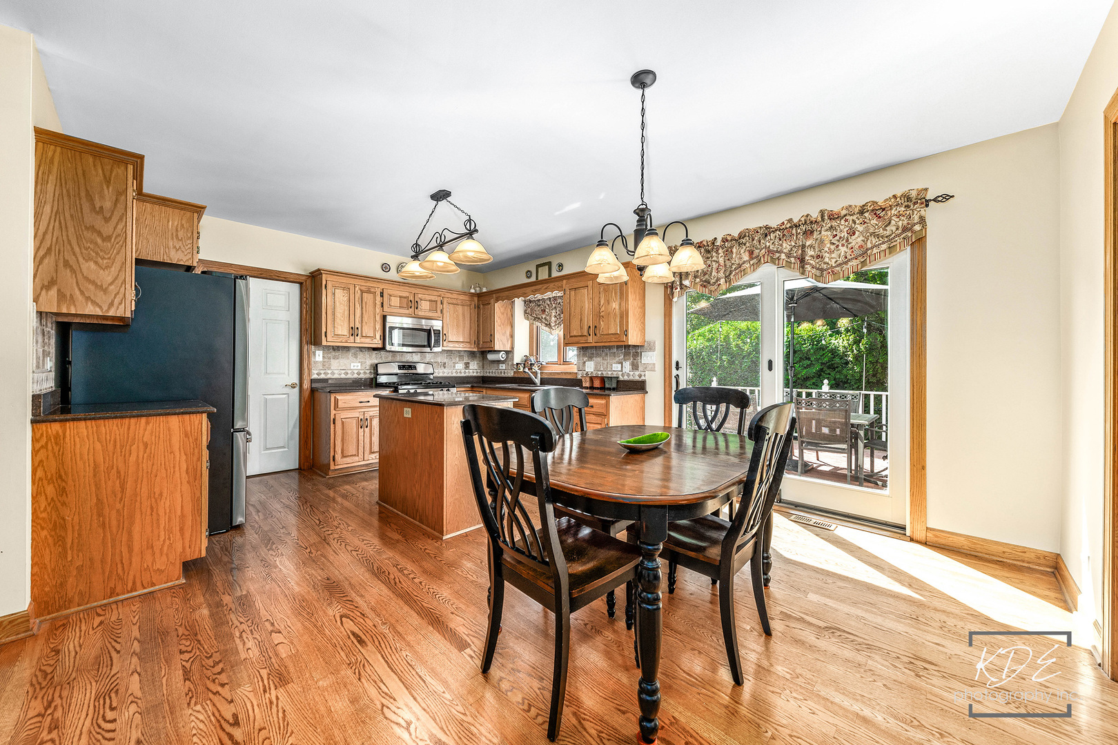 1032 Hamlet Road Naperville, IL 60564 - Photo 15 of 38 a view of a dining room and livingroom with furniture wooden floor a chandelier