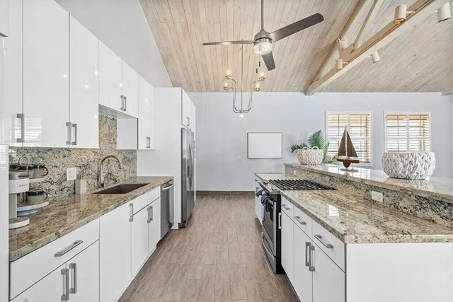 a kitchen with stainless steel appliances kitchen island a chandelier and refrigerator