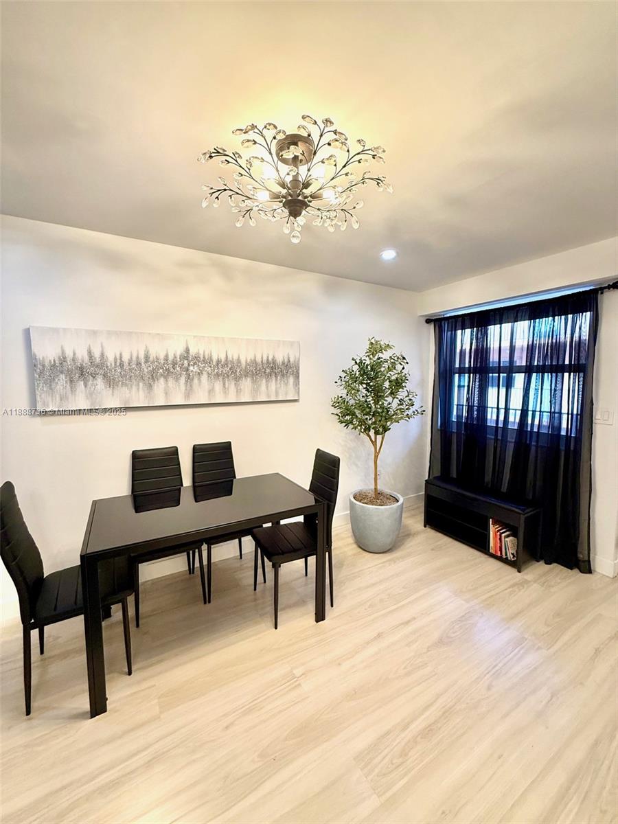 199 Southwest 12th Avenue, Unit 404A Miami, FL 33130 - Photo 11 of 65 a view of a dining room with furniture and wooden floor