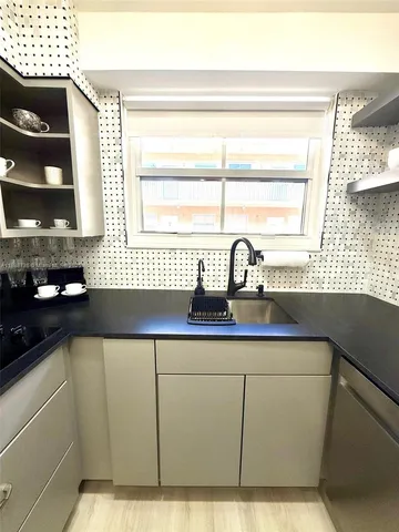 a kitchen with a sink a window and cabinets