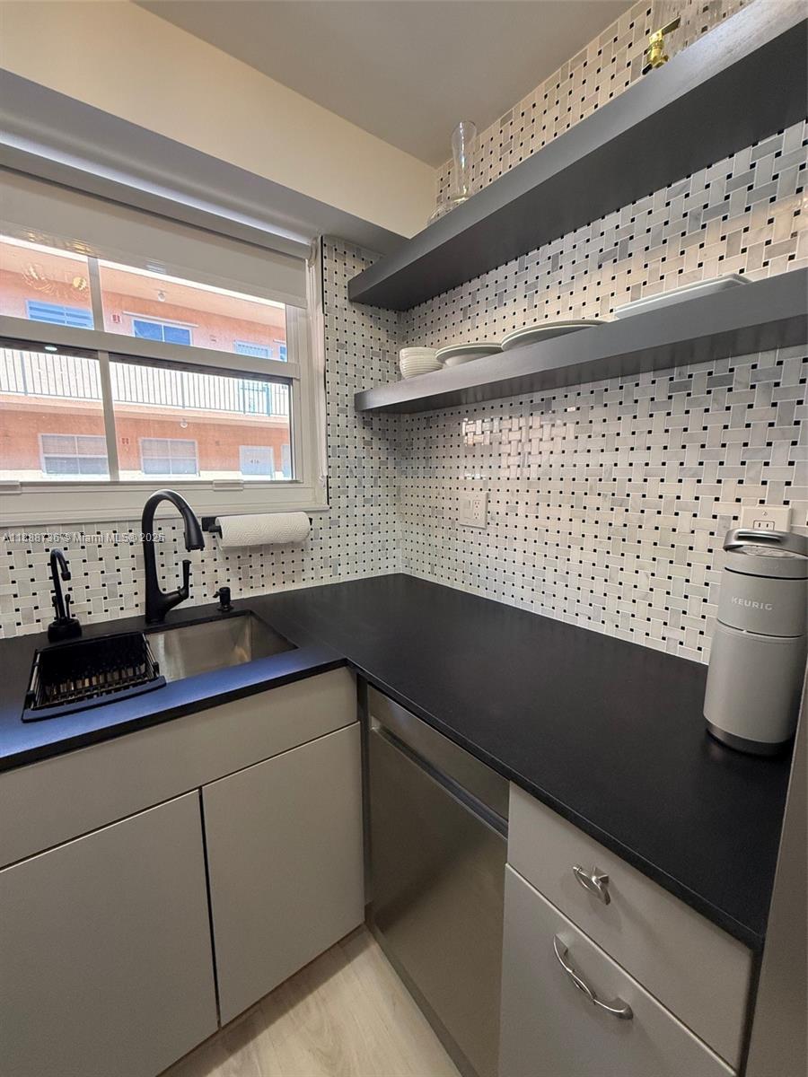199 Southwest 12th Avenue, Unit 404A Miami, FL 33130 - Photo 22 of 65 a kitchen with a sink a window and cabinets