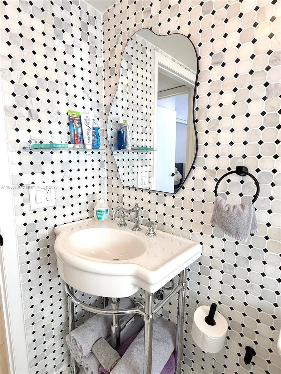 199 Southwest 12th Avenue, Unit 404A Miami, FL 33130 - Photo 32 of 65 a bathroom with a sink a toilet and shower curtain