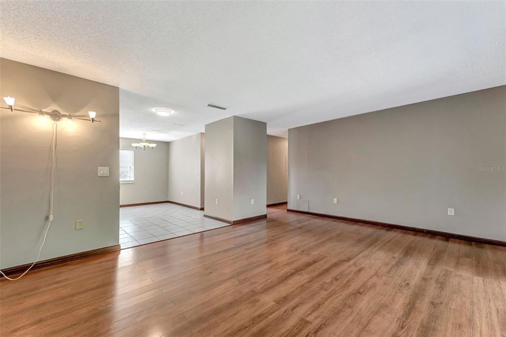 13300 Walsingham Road, Unit 56 Largo, FL 33774 - Photo 12 of 35 a view of an empty room with wooden floor and a window