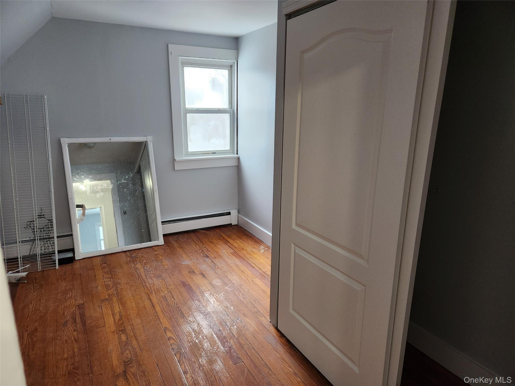 72 Stanton Corner Road, Unit 2 Swan Lake, NY 12783 - Photo 3 of 7 an empty room with wooden floor and windows