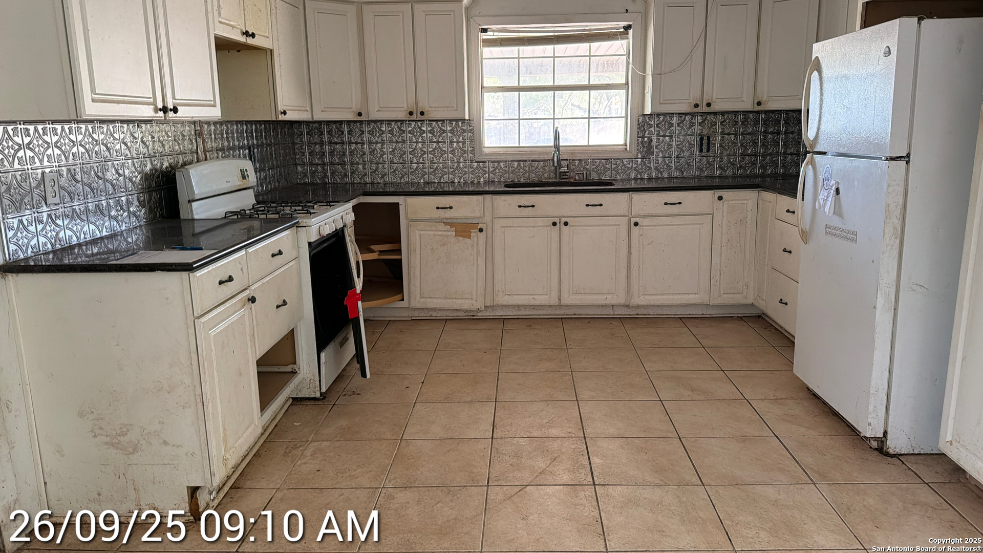 218 Graham Road Kenedy, TX 78119 - Photo 10 of 19 a kitchen with granite countertop a sink a stove a refrigerator and cabinets