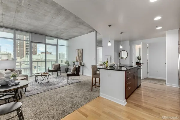 a large living room with stainless steel appliances granite countertop a couch and wooden floor