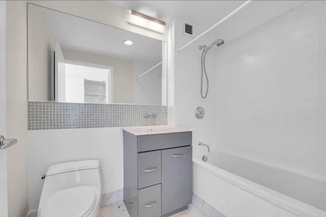 a bathroom with a shower sink vanity mirror and toilet