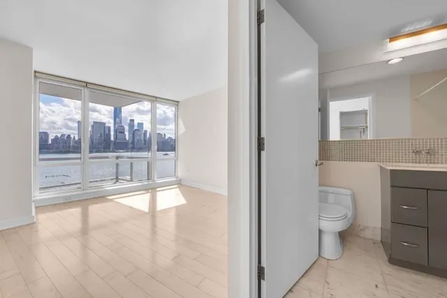 a bathroom with a toilet sink and a large mirror