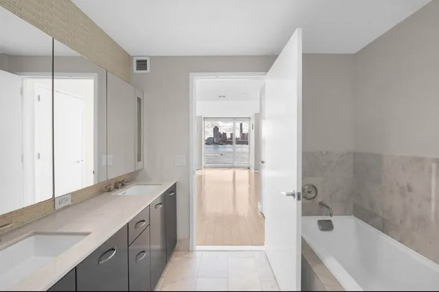 a bathroom with a tub sink and mirror